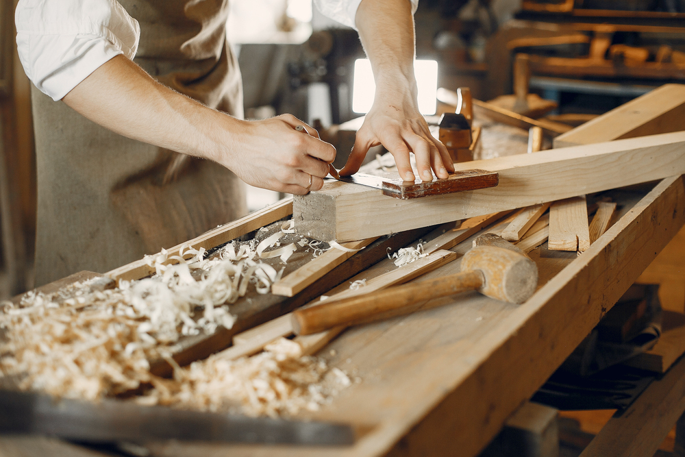 Handsome carpenter working with a wood
